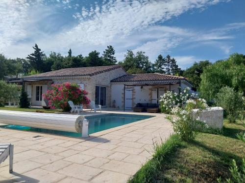 une maison avec une piscine dans une cour dans l'établissement L'atelier provençal, à Malataverne