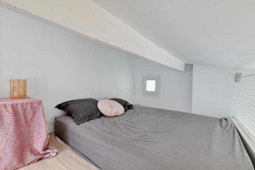 un lit dans une chambre blanche avec un escalier dans l'établissement Coquet appartement en bord de mer et corniche, à Marseille