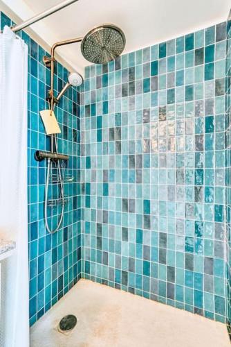 une salle de bain avec douche aux carreaux bleus dans l'établissement Coquet appartement en bord de mer et corniche, à Marseille