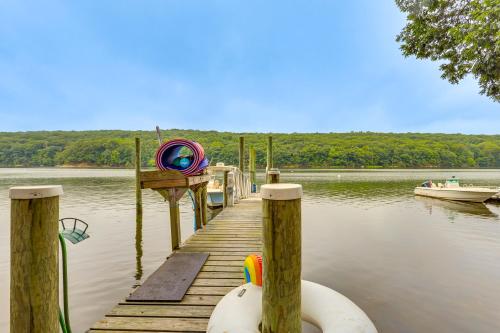 a dock on a body of water with a boat at Charming Waterford Home with Dock on Niantic River! in Waterford