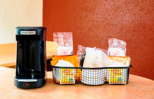 a coffee maker sitting next to a basket of food at Red Roof Inn Allentown Airport in Allentown