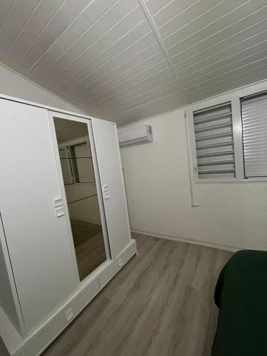 an empty room with a mirror and a window at Cocon douillet entre Mer et Montagne in Basse-Terre