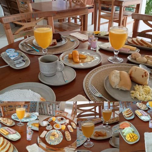 a table with plates of food and glasses of orange juice at Quinta Brasilis Boutique Hotel Paraty in Paraty