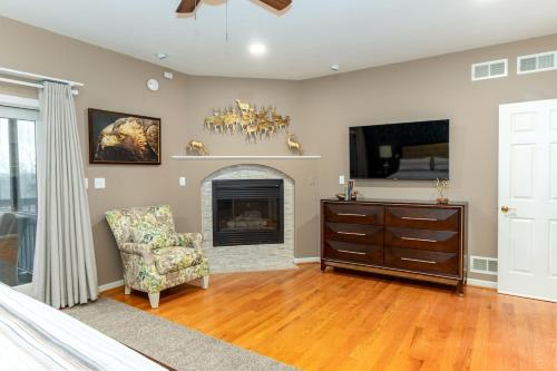 a living room with a fireplace and a chair at Secluded 4 bedroom with hot tub minutes from campus in State College
