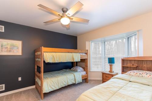 a bedroom with two bunk beds and a ceiling fan at Secluded 4 bedroom with hot tub minutes from campus in State College