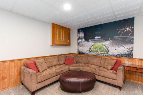 a living room with a couch and a picture of a baseball game at Secluded 4 bedroom with hot tub minutes from campus in State College