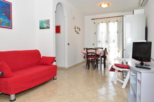 sala de estar con sofá rojo y mesa en Case Vacanza Maria, en San Vito lo Capo