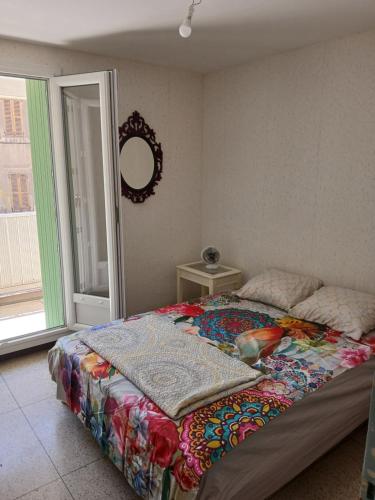 une chambre avec un lit avec une couette dessus dans l'établissement Chambre avec balcon dans une appartement la belle de mai, à Marseille