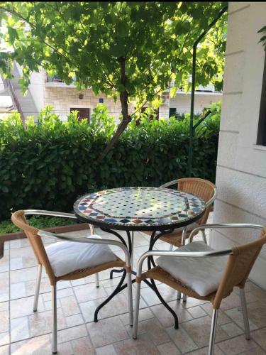 a patio table and two chairs and a table and chairs at Apartments Ćošković in Podgora
