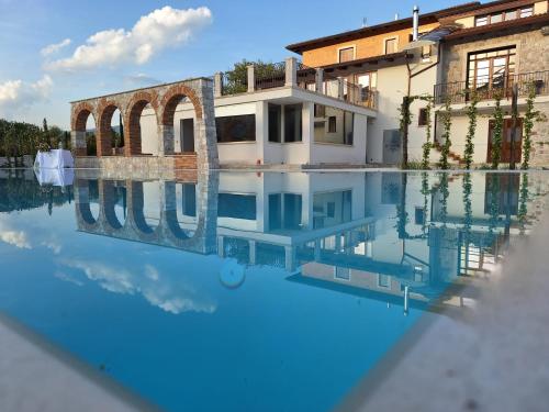 a villa with a pool in front of a house at TENUTA ROSA - Gastronomia e Relax in Montesano Scalo