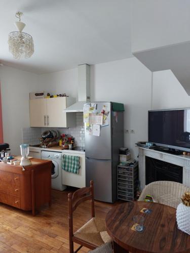 Il comprend une cuisine équipée d'un réfrigérateur et d'une table. dans l'établissement Lumineux, à Vitry-sur-Seine