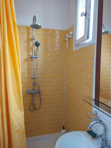 La salle de bains est pourvue d'une douche avec rideau de douche jaune. dans l'établissement Lumineux, à Vitry-sur-Seine