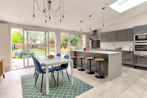 - une cuisine avec une table et des chaises dans l'établissement Charmante maison - Proche JO 2024, à Montigny-le-Bretonneux