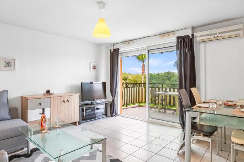 un salon avec une table en verre et une télévision dans l'établissement Haut Standing /Mandelieu - Cannes, à Mandelieu-la-Napoule