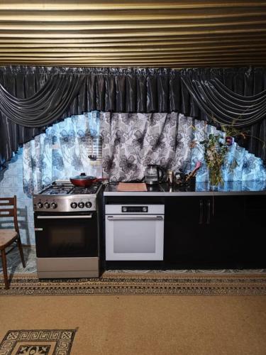 a kitchen with a stove and a counter top at M & D hotel in Tsqaltubo