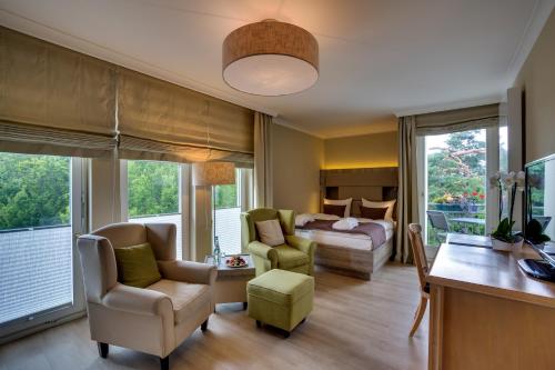 uma sala de estar com uma cama, um sofá e cadeiras em Upstalsboom Heringsdorf em Heringsdorf