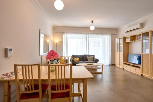 a living room with a table and a couch at FortCambridge 2BR, pool, Terrace in Sliema
