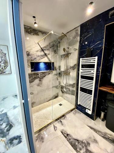 une salle de bain avec une douche avec une porte vitrée dans l'établissement Appartement chic, quartier calme, à Clichy-sous-Bois