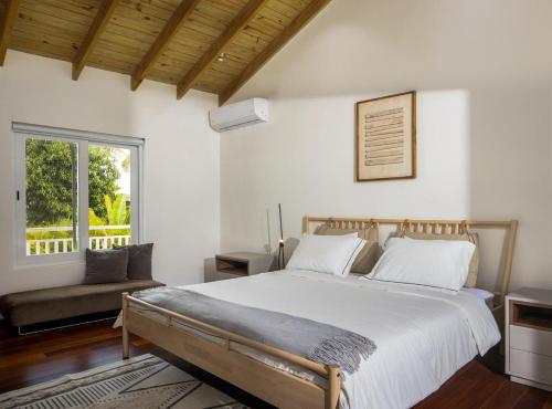 a bedroom with a large bed and a window at Beachfront 3BD Luxury Villa with full hotel access in Cabarete