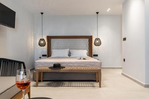 a bedroom with a bed and a glass of wine at Lianos Village in Agios Prokopios