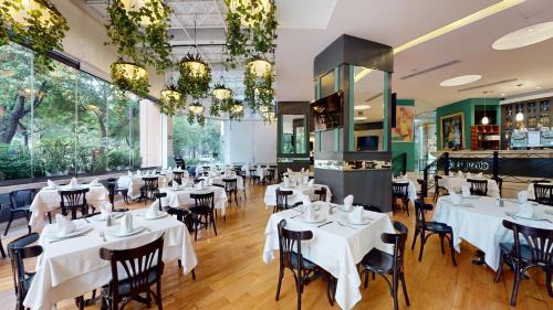 a dining room with white tables and chairs at Hotel Marquis Reforma in Mexico City