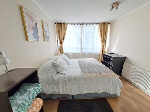 a bedroom with a bed and a desk and a window at Bellavista Cozy Apartment in Santiago