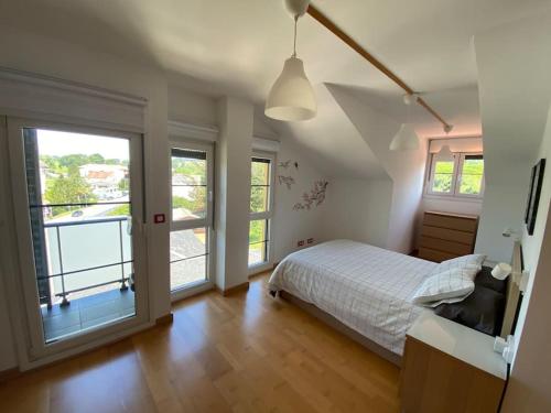 Un dormitorio con una cama y una ventana grande en Ático de Ensueño- Tu Paraíso en Cantabria, en Beranga