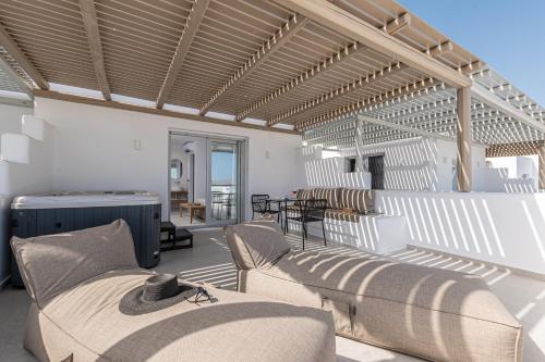 a patio with chairs and tables on a building at Lianos Village in Agios Prokopios