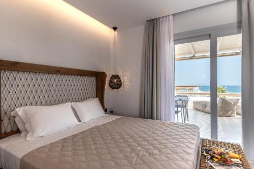 a bedroom with a bed and a view of the ocean at Lianos Village in Agios Prokopios