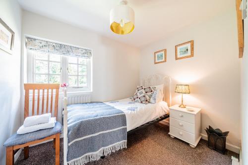 a small bedroom with a bed and a window at Beautiful Riverside Cottage with Large Garden, 2BR in Boldre