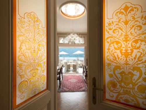 una puerta abierta a un comedor con una lámpara de araña en Dermuth Hotels – Parkvilla Wörth, en Pörtschach am Wörthersee