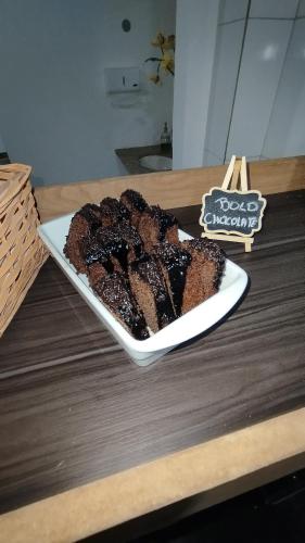 a plate of cake sitting on a table at DLUX Hotel in Campos dos Goytacazes