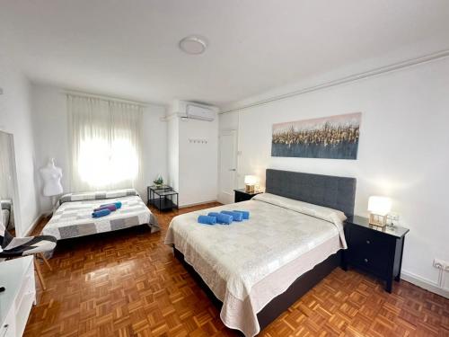 a bedroom with two beds and a painting on the wall at Rooms in Apartment Rambla Catalunya in Barcelona