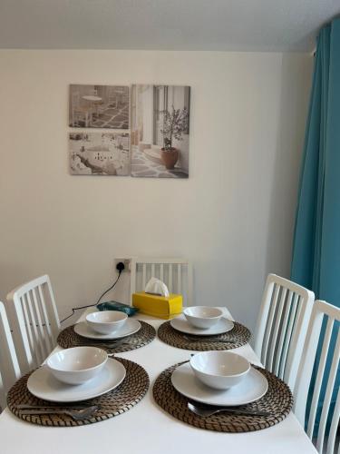 a table with four bowls and plates on it at Lovely Entire Flat with Private Balcony in Euston-Central London in London