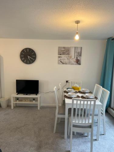 a dining room with a table and chairs and a clock at Lovely Entire Flat with Private Balcony in Euston-Central London in London
