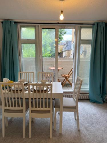 a dining room with a table and chairs and a window at Lovely Entire Flat with Private Balcony in Euston-Central London in London