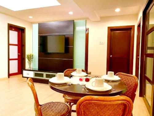 a dining room with a table and chairs and a television at Platinum Homestay in Batu Caves
