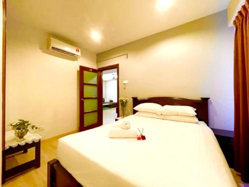 a bedroom with a large bed with white sheets at Platinum Homestay in Batu Caves
