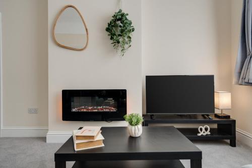 a living room with a tv and a coffee table at Large cosy house - free on street parking in Liverpool