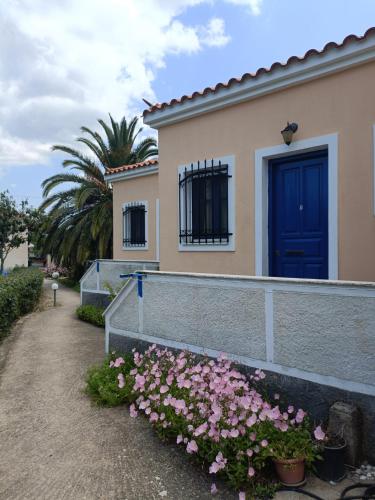 ein Haus mit blauer Tür und rosa Blumen in der Unterkunft Anna Daniil Oasis Studios Skala Kallonis Lesvos in Skala Kallonis