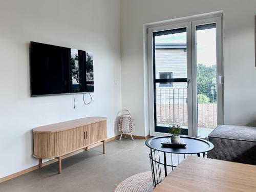 a living room with a couch and a tv on a wall at Ferienwohnung Schottenhof Walser 3 - Alleinlage im Grünen mit Panoramablick in Achberg