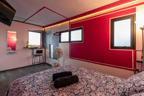 a bedroom with a bed and a red wall at Posada Bugambilia in Mexico City