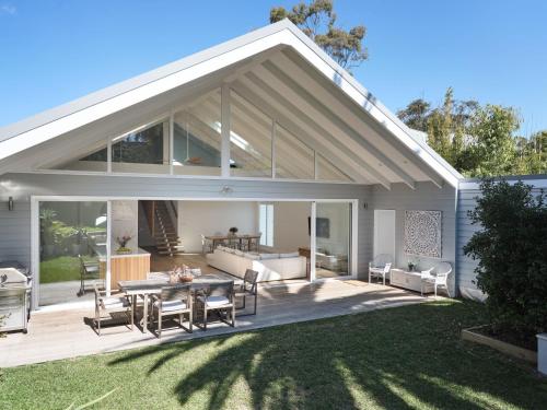 an open patio with a table and chairs at Bareena House by Beach Stays in Avalon