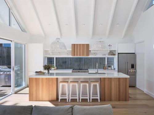 a kitchen with a large island in a room at Bareena House by Beach Stays in Avalon