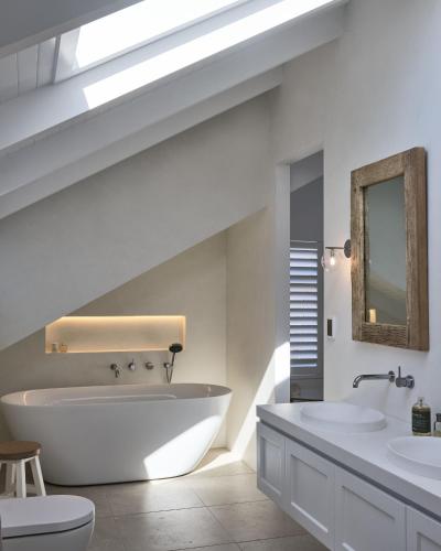a bathroom with a large tub and two sinks at Bareena House by Beach Stays in Avalon