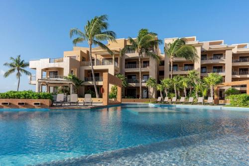 ein großes Schwimmbad vor einem Gebäude in der Unterkunft EL FARO 204 SURF two bedrooms apartment ocean front in Playa del Carmen