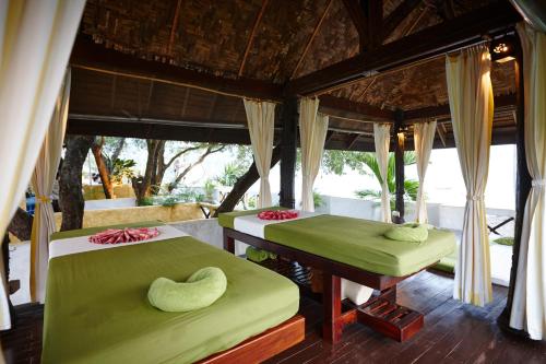 two beds in a room with green sheets at Vacation Village Phra Nang Lanta - SHA Extra Plus in Ko Lanta