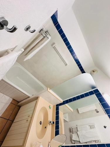 une salle de bain avec du carrelage bleu et blanc au plafond dans l'établissement Tout près des vagues, à Lacanau