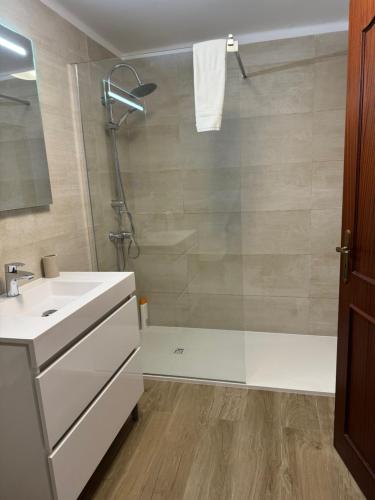 a bathroom with a shower and a sink at Coast Beach Apartment - Praia da Areia Branca in Praia da Areia Branca