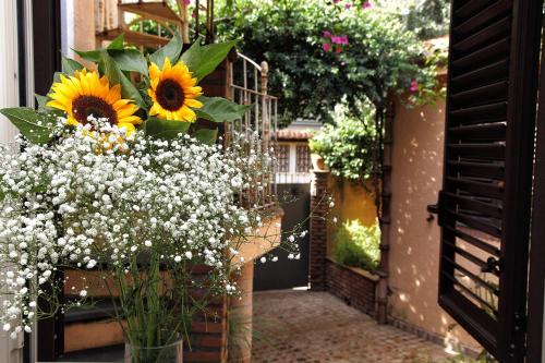 a vase of sunflowers and flowers on a porch at Torre Di Sebastiano in Gaggi